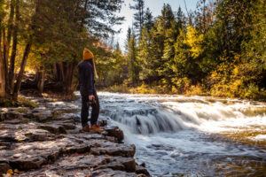 A woman stands at the edge of Ocqueoc Falls 